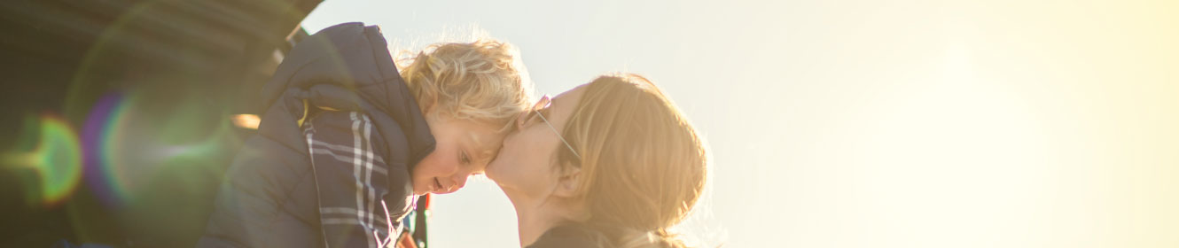 woman kissing boy on forehead