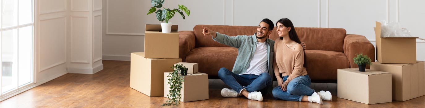 A couple sitting on floor of their new home