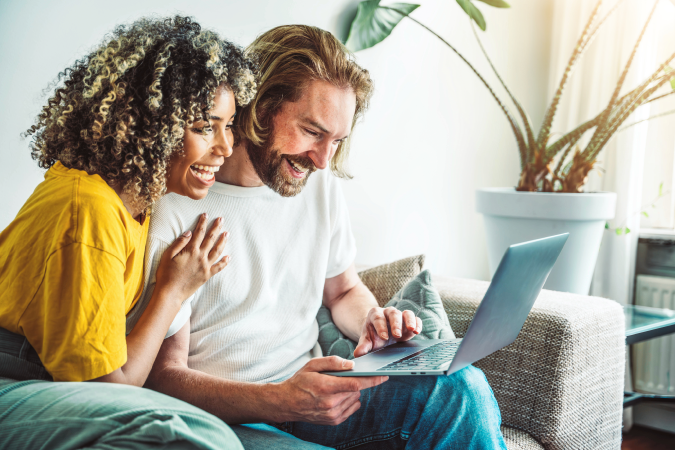 Happy couple on sofa receiving good news